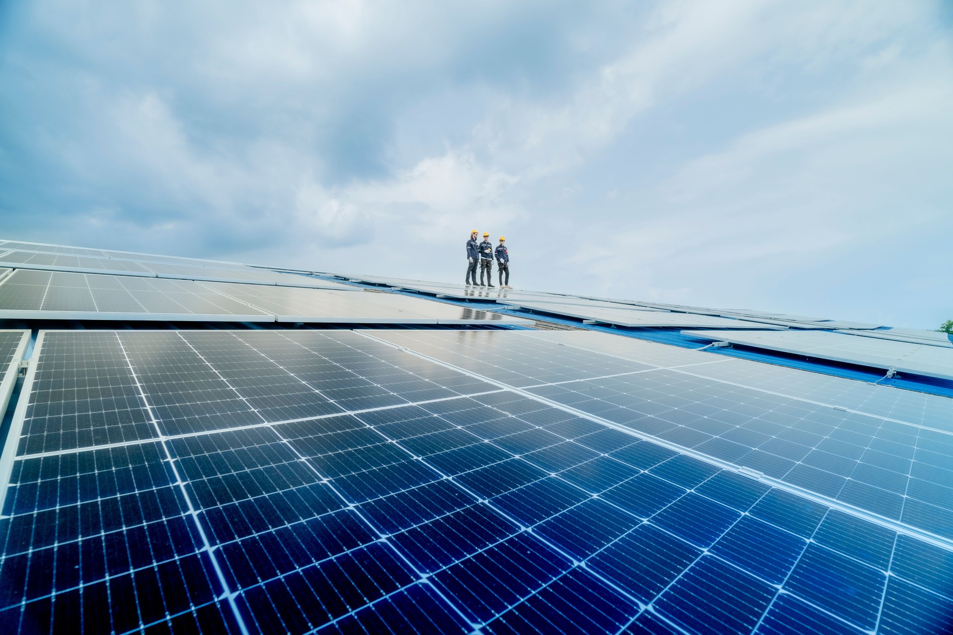 engineer man inspects construction of solar cell panel or photovoltaic cell by electronic device. Industrial Renewable energy of green power. factory worker working on tower roof.