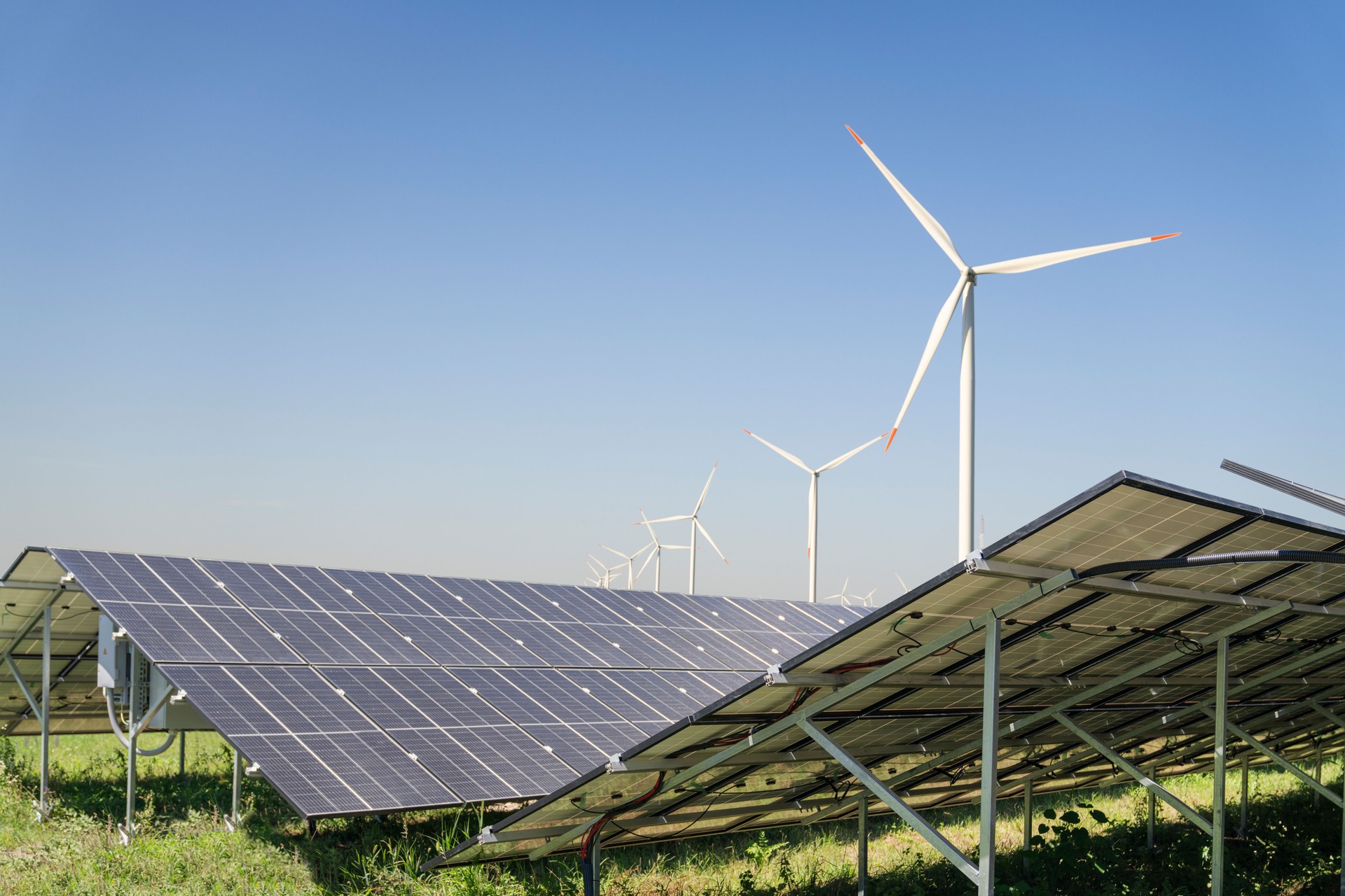 Solar panels and wind turbines on a field. Sustainable energy.
