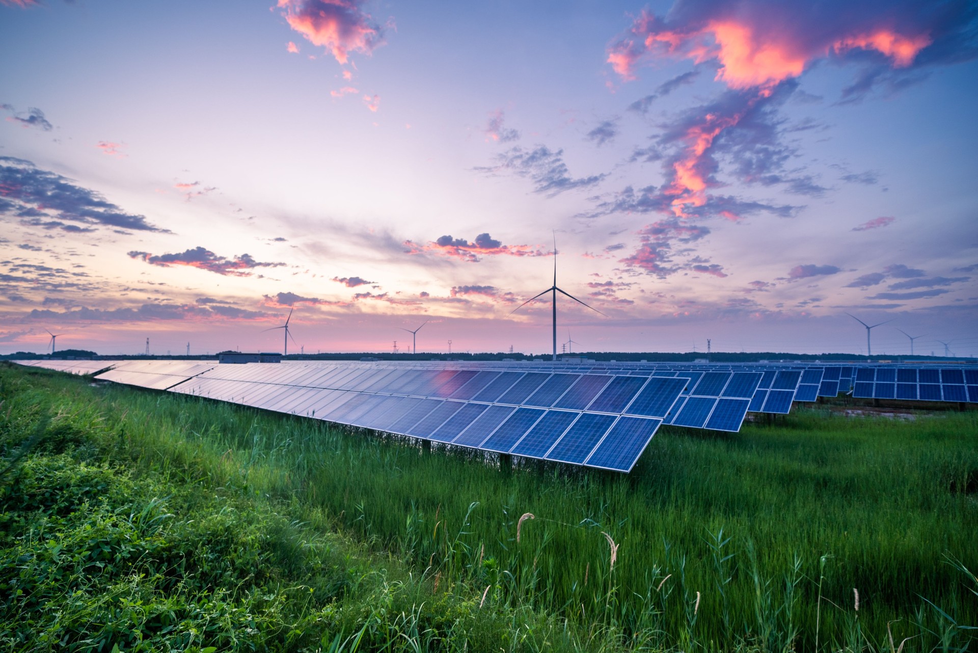 solar power station and wind turbines at sunset